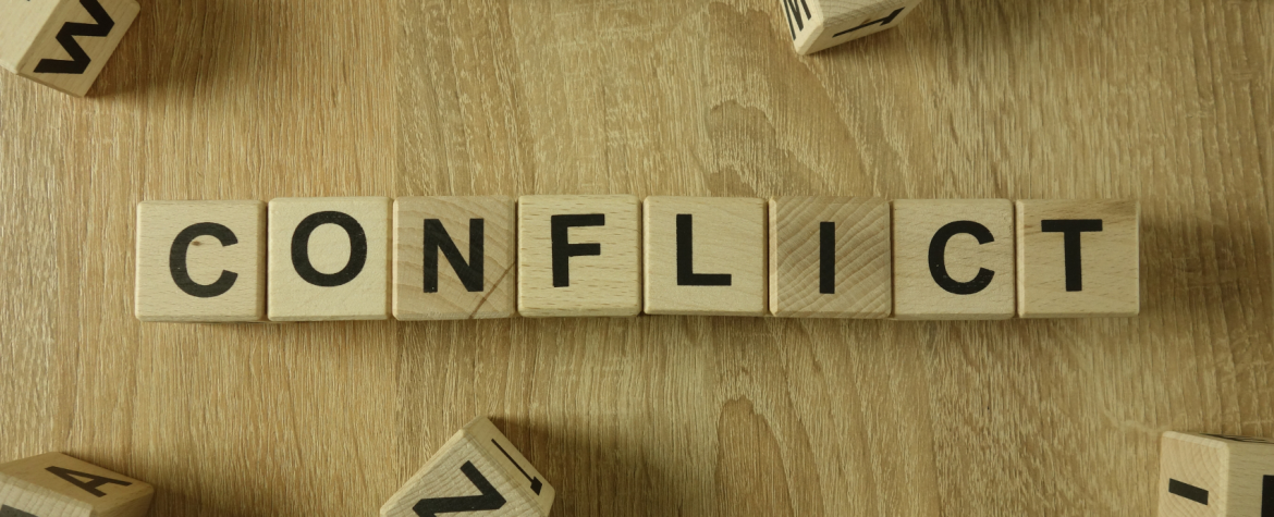 Illustration of letter tiles spelling out Conflict.
