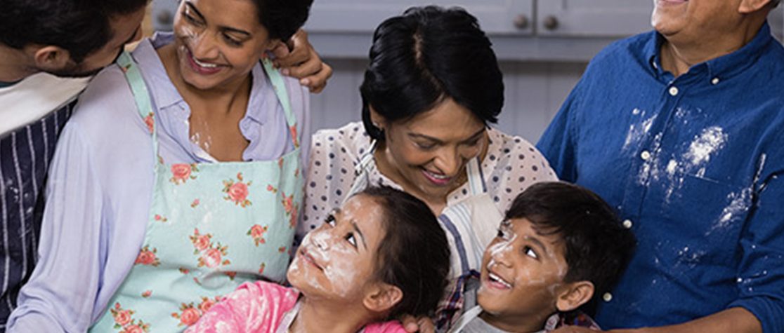 Group of people baking together with flour all over them.