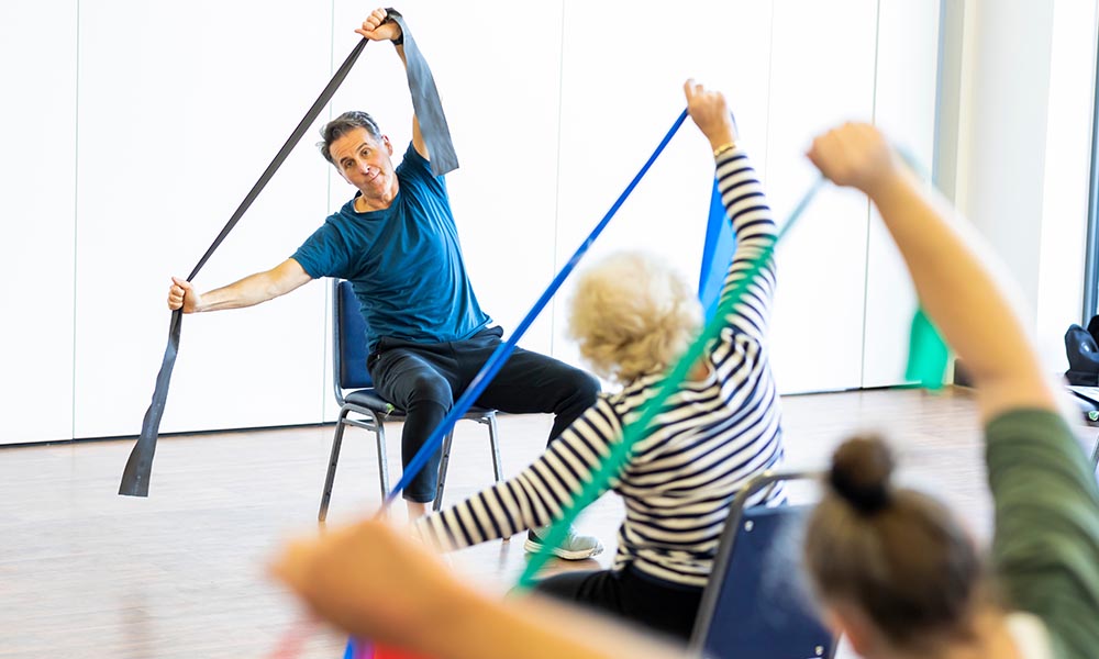 People using resistance bands in an exercise session.