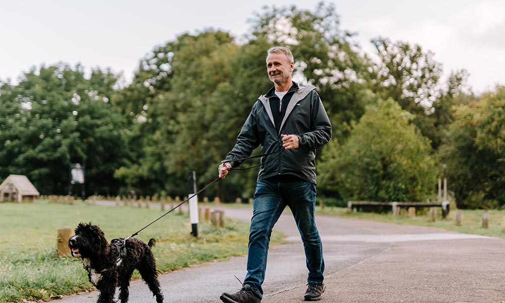 A man walking his dog in the park.