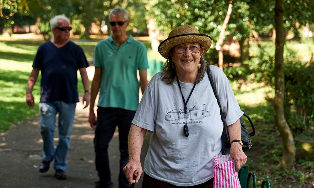 People out walking in the park in the sun.