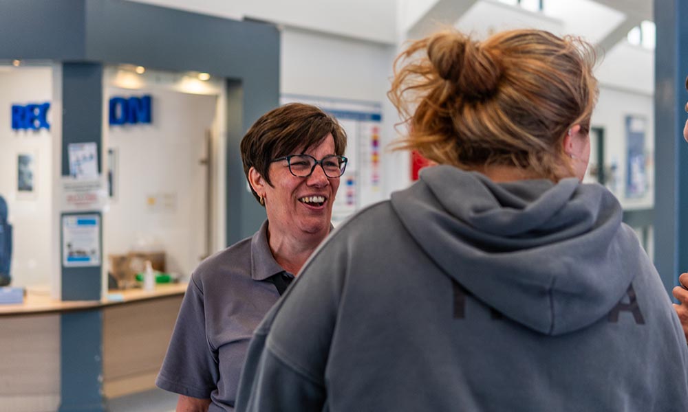 Two colleagues talking in a reception area.