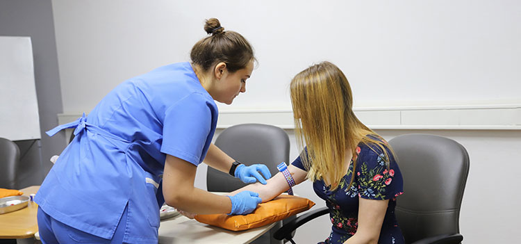 A nurse taking blood.