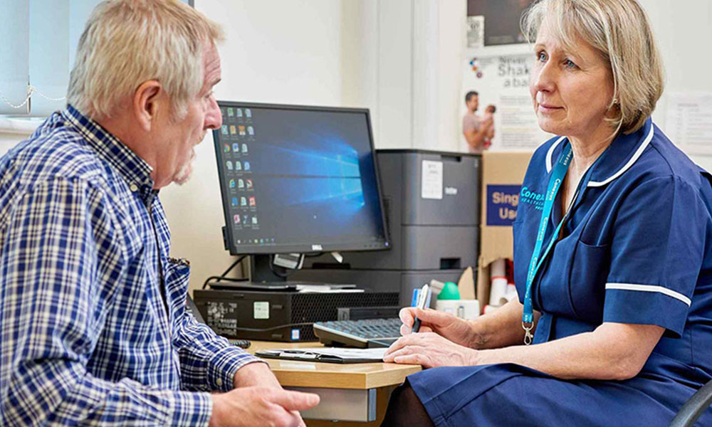 A nurse talking to a patient.