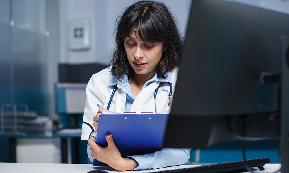 A doctor making notes on a clipboard.