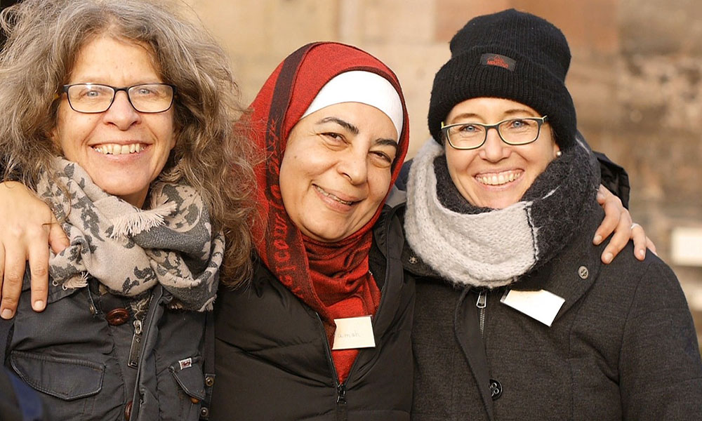 Three women smiling for a photo.