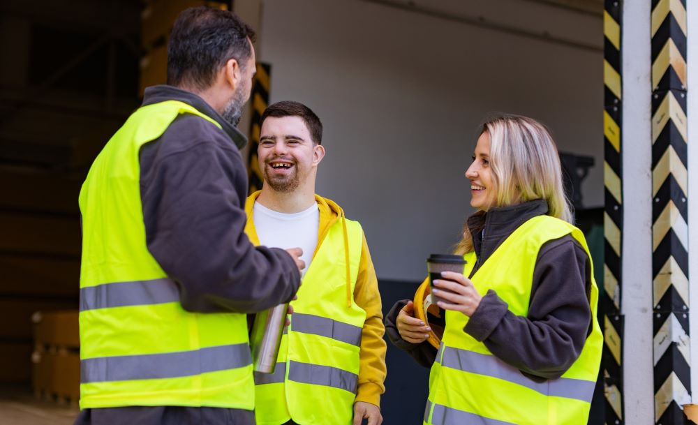 Three people is high vis jackets outside a warehouse