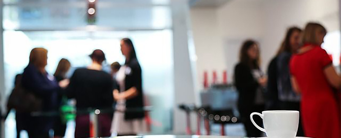 Out of focus photo of a group of colleagues having coffee.